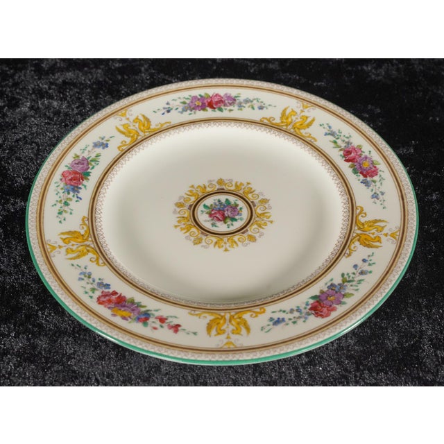 This salad plate is made of white fine bone china and is decorated with a multicolored floral and mythical griffin motif....