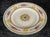 This salad plate is made of white fine bone china and is decorated with a multicolored floral and mythical griffin motif....