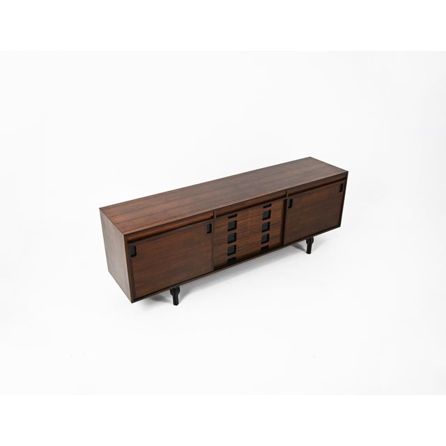 Wooden sideboard with 8 drawers and 2 sliding doors, containing a shelf, by Renato Magri. Wear consistent with age and...