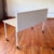 White metal desk with light wood veneered table top and grey fabric privacy barrier. This desk has all the convenient...