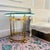 An exceptionally elegant vintage brass side table featuring four sculptural swan head supports beneath a substantial...