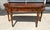 This elegant foyer table features a richly figured wood top accented with decorative banding and gracefully rounded ends...