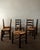 A vintage French dining chair set in dark stained wood and woven rush, attributed to Georges Robert and produced in France...