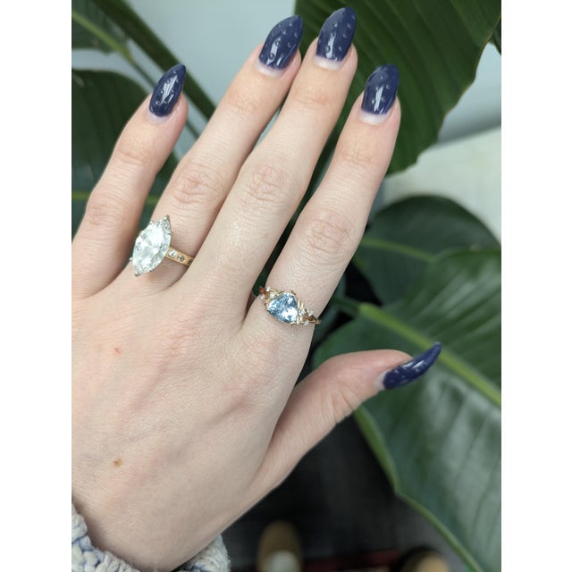 Radiant 8 mm trillion aquamarine set in lustrous Solid 14k Gold with shimmering natural diamond accents. A modern gem-...