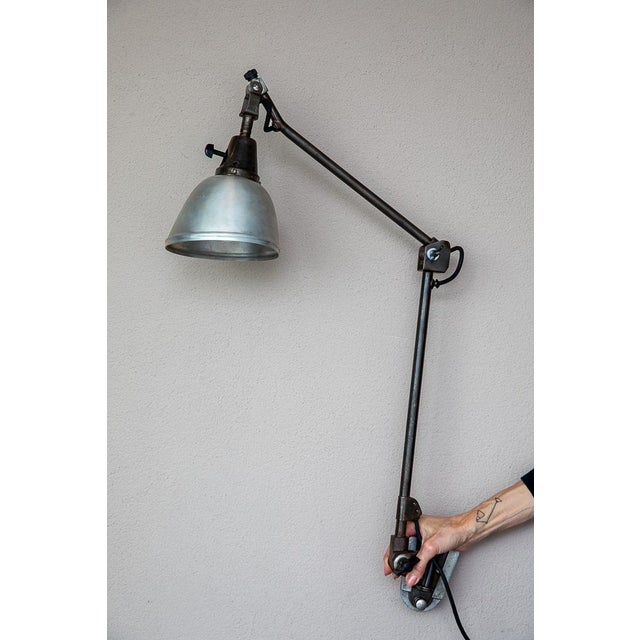 Beautiful Midgard Type 114 two-arm wall lamp with a parabolic metal shade. The conical jointed head on the shade is...