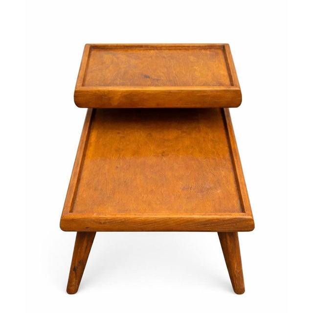Mid-century two-tier side table with a raised platform and curved support. Warm walnut tone with beautiful grain.