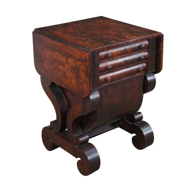 An exceptional early 19th century drop leaf sewing work table. Features a crotch mahogany frame with a drop leaf over two...