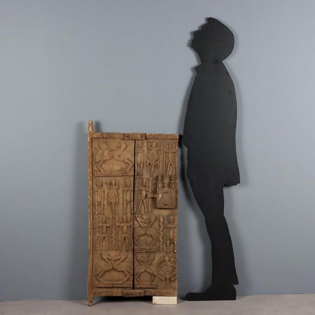 Wooden and metal granary door with representations of sacred animals and a lock carved with figures of the primordial...