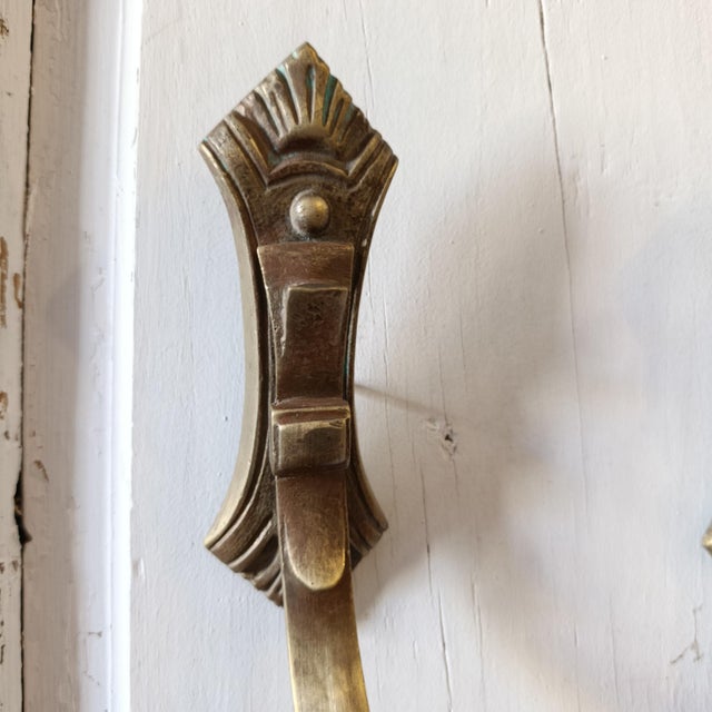 A striking pair of vintage French bronze curtain tiebacks featuring sculptural curved arms and distinctive architectural...