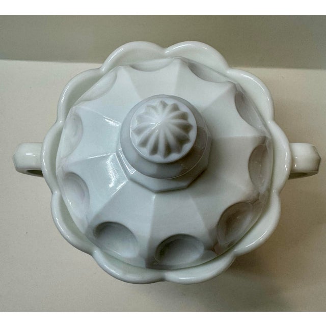 A substantial and pristine example of mid-century American milk glass, this is the large #109 Paneled Cherry Cracker Jar...