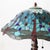 A Tiffany-style table lamp, crafted in the 20th century, features a dome-shaped shade composed of numerous pieces of...
