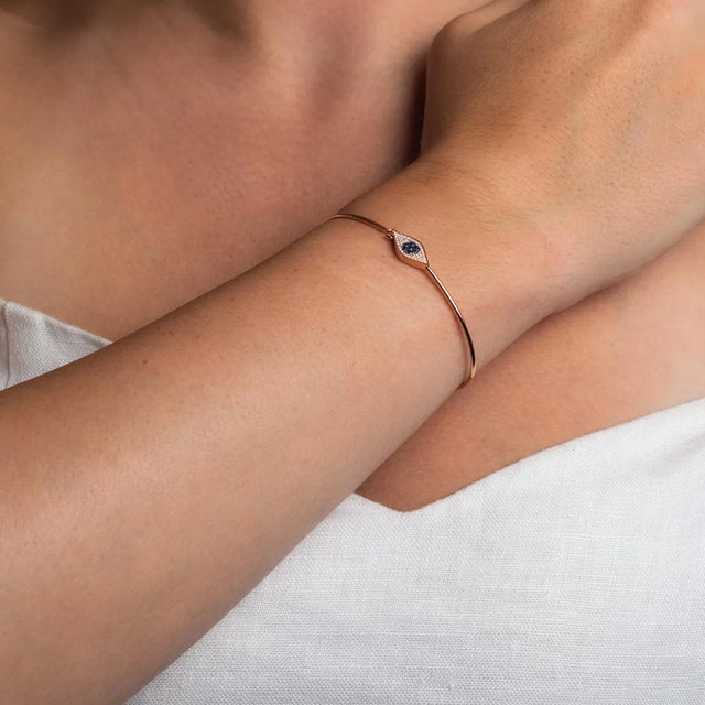 This is part of Chairish’s Fine Jewelry assortment. Kerri's favorite. This diamond and sapphire evil eye bangle is every...