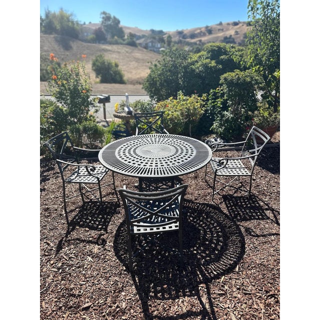 Contemprory dining set by Woodard made of cast aluminum(never rusting material) Round table and 4 armchairs table measures...