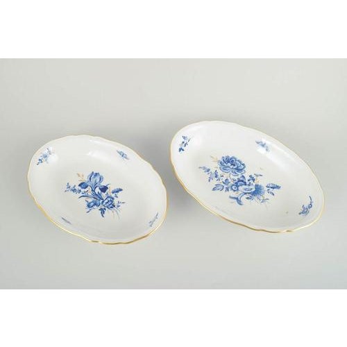 Meissen Two oval serving dishes, mid-20th century. Hand-decorated porcelain with hand-painted blue floral motifs and gilt...