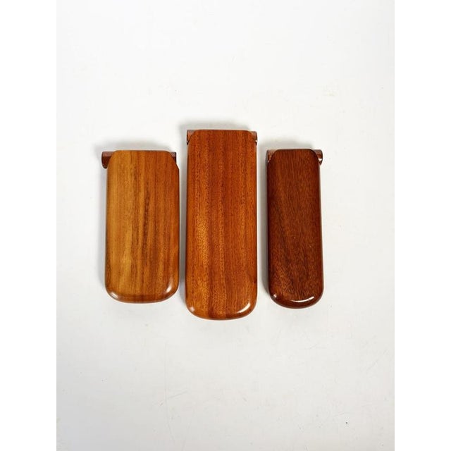 Set of three wooden cigar boxes, typical of the 1970s, designed for storing and displaying cigars. Each box has a simple,...