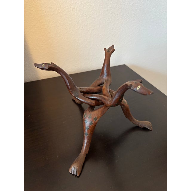Description A finely carved mid‑20th‑century hardwood serpent tripod stand, crafted from a single block of wood and...
