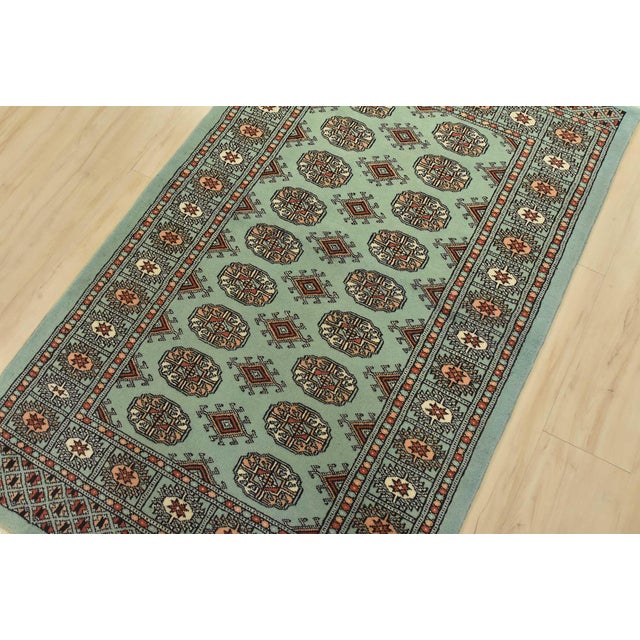 A tribal Bokhara rug hand-knotted with fine wool on a cotton foundation. This rug features rows of repeating medallions...