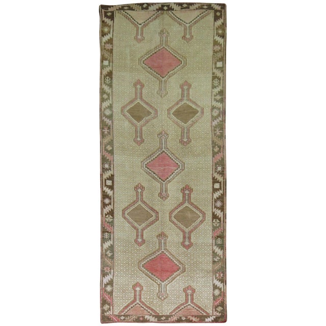 Quirky mid-20th century Turkish gallery rug. Pink and brown medallions on a khaki ground and brown border, circa 1940....