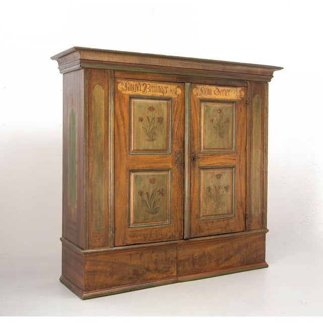 A rare Swiss wedding armoire made of solid pine, dating from the late 18th century. It features a beautifully...