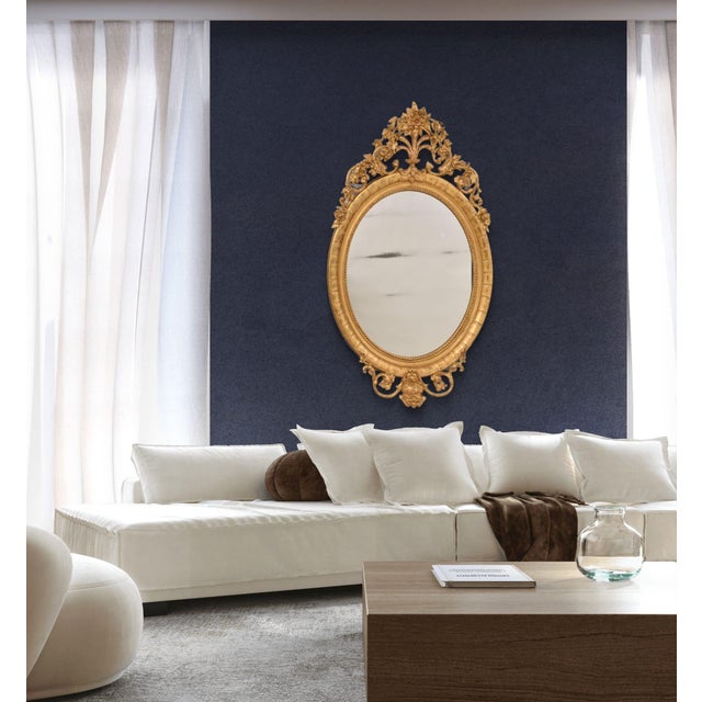 The Large Antique Oval Wall Mirror with Cimasa richly decorated with flowers, leaves and scrolls, proposed here is an...