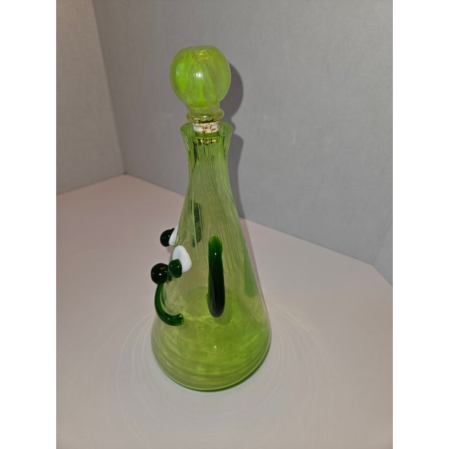 This mid century modern green art glass decanter was produced by Fratelli Toso for Murano in the 1960s. Styled with...