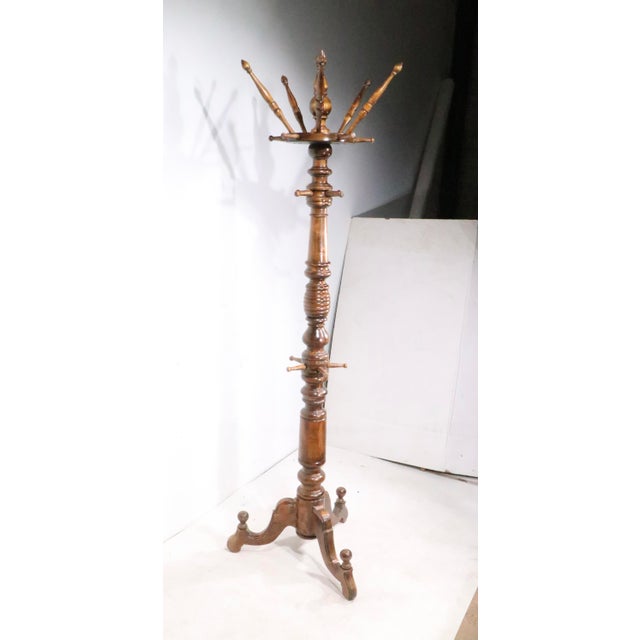 Exceptional Victorian, Renaissance Revival, style walnut coat tree, having five hooks at the top, which rotate around the...