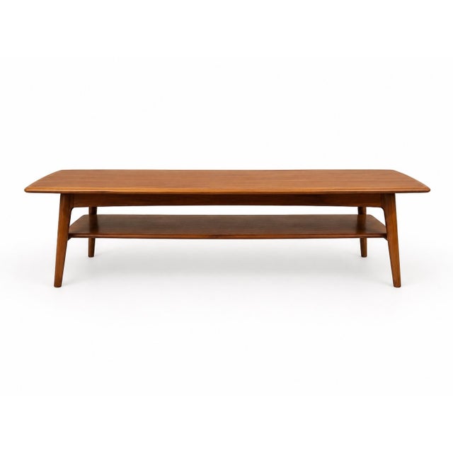 An elegant Danish Modern teak coffee table designed by H.W. Klein for Bramin Møbler, Denmark, circa 1960s. This...