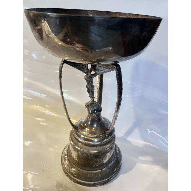 A very nice 1990’s English silverplate golf trophy with a golfer figure in the center under the cup. Three golf clubs are...