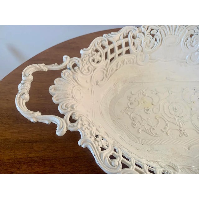 A decorative French country–style cachepot in cast iron, featuring an intricately reticulated rim and scrolling handles....