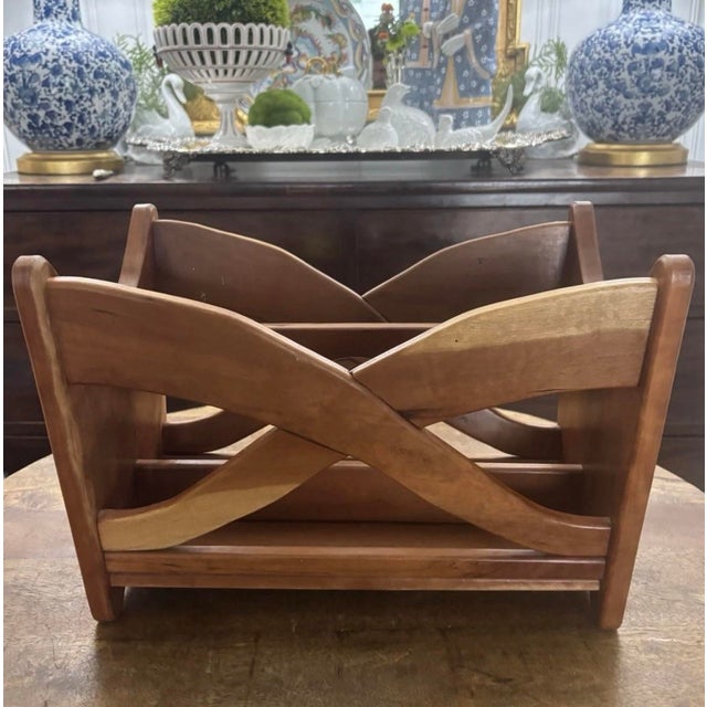 Vintage mid-century modern wooden magazine rack featuring gracefully curved crossed side supports, sculptural openwork...