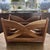 Vintage mid-century modern wooden magazine rack featuring gracefully curved crossed side supports, sculptural openwork...