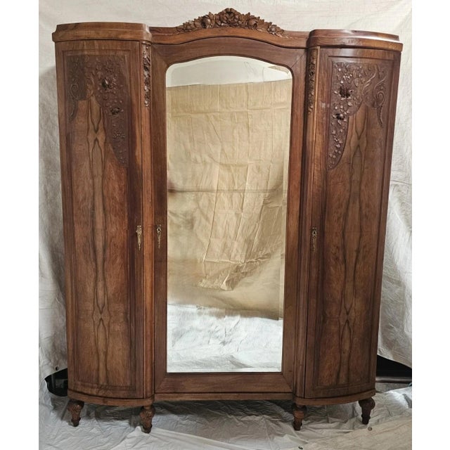 Circa 1920s | Floral Carvings | Adjustable Shelving | Exceptional Figured Walnut An elegant and highly decorative French...