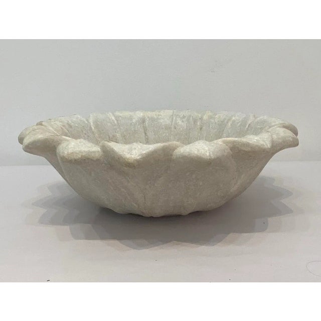 Craved marble lotus bowl with foliate designed rim. Delicately craved beautiful accent piece for your garden.