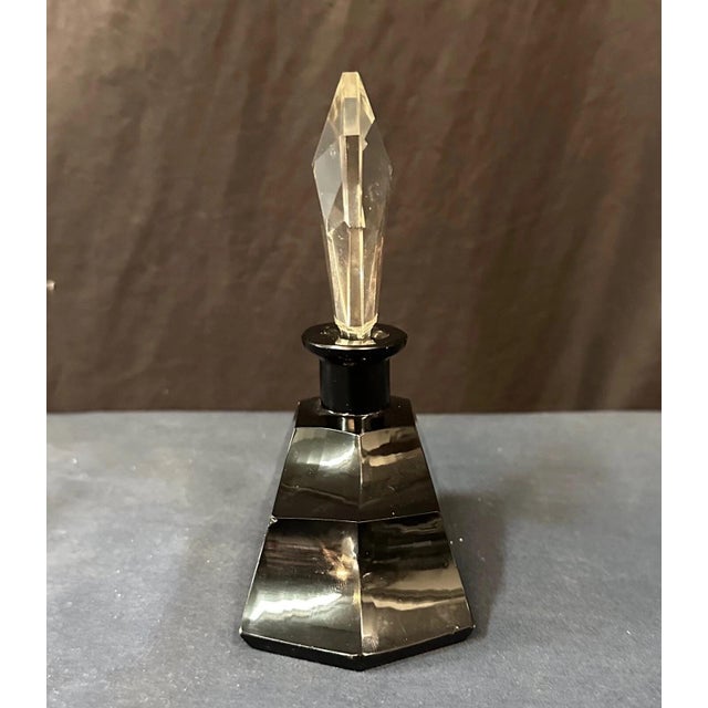 This vintage early 20th century Art Deco vanity perfume bottle is designed in Czechoslovakian black glass accented with a...