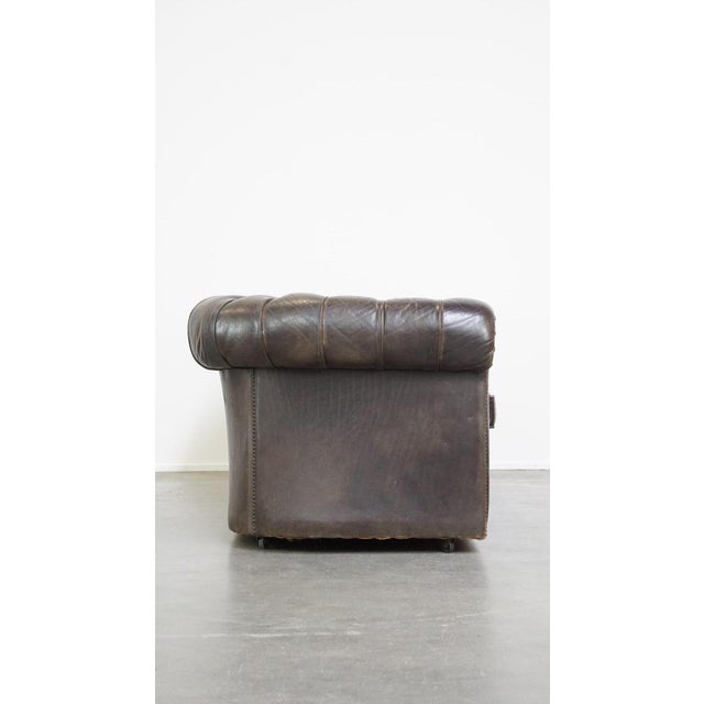 This old dark brown 3-seater cowhide chesterfield sofa with lots of character. This beautiful, old dark brown 3-seater...