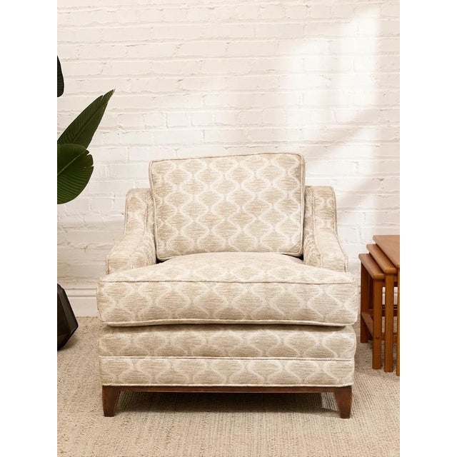 A generously proportioned vintage lounge chair upholstered in a beautiful champagne-toned jacquard with a repeating...