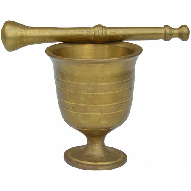 Vintage cast brass mortar & pestle with ornate details. Pestle: 7" L x 1.25" W; Mortar: 3.5" D x 4.25" H. This gorgeous...