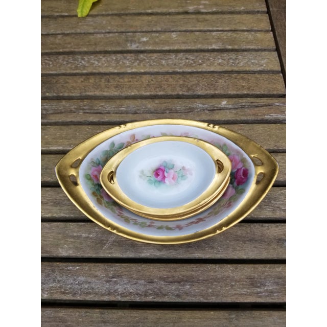 A little set of RS China from Germany nut bowl and dishes. each piece has lots of gold and two pink roses with green...