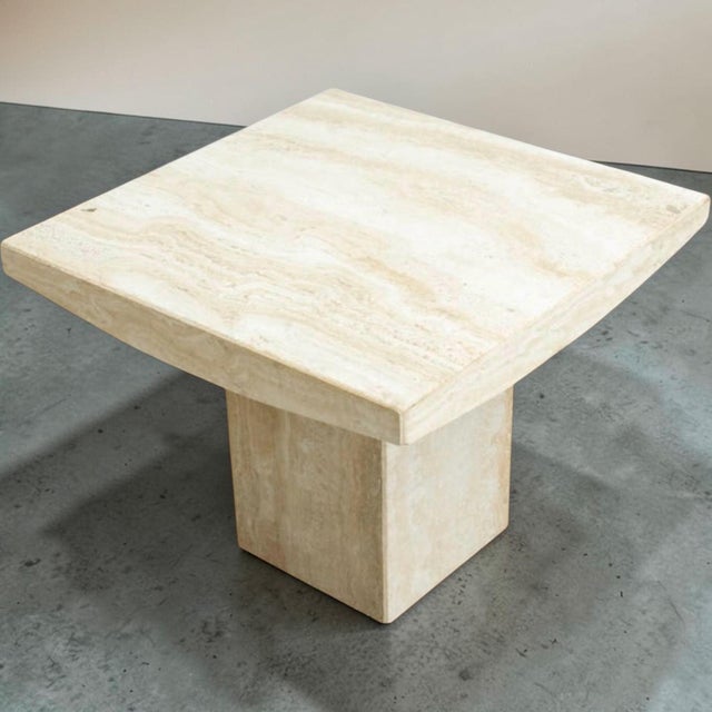 This is a pair of 1970s Italian organic modern travertine side tables. They have sculpted tops resting on block bases. The...