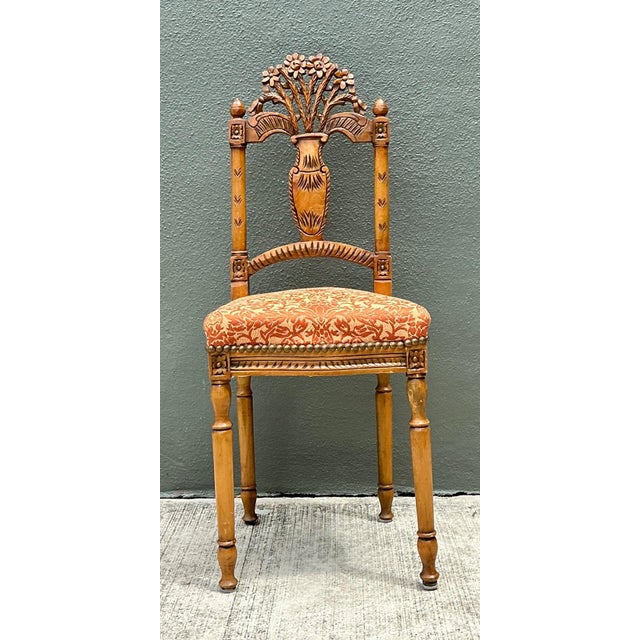 This vintage side chair is carved from richly grained wood, with an intricate floral and foliate motif rising up the crest...