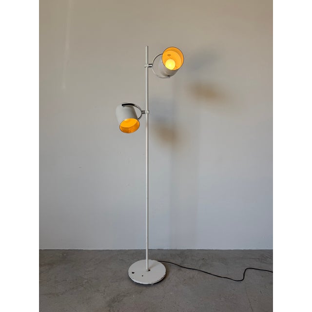A sleek and highly functional 1970s Mid-Century Modern floor lamp by Lightolier, featuring two adjustable metal shades...