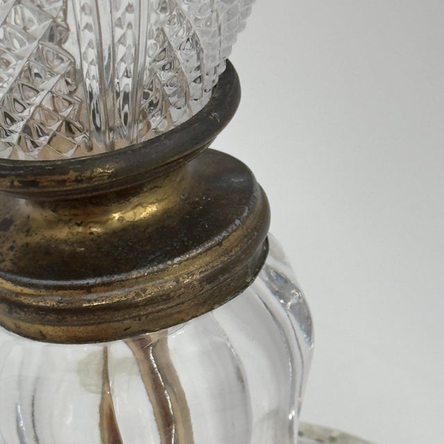 Vintage Hollywood Regency table lamp featuring a substantial cut-glass urn-form body with diamond-pattern detailing, brass...