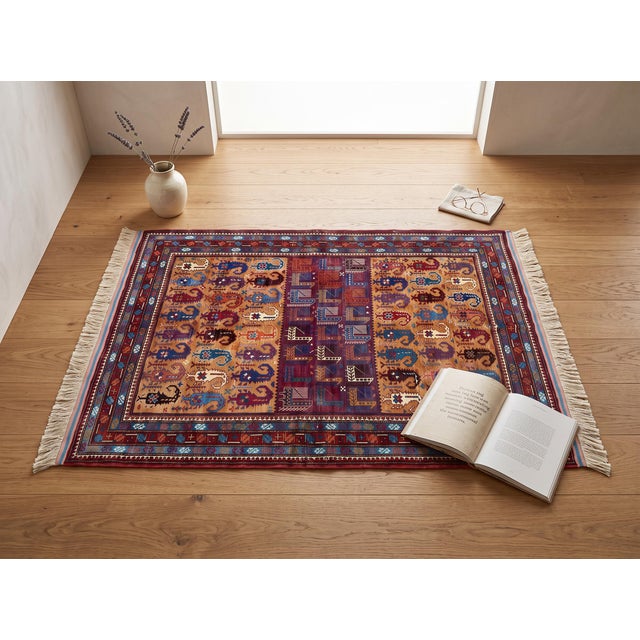 Columns of curling ram's-horn boteh in red, blue, teal, and ivory line the honey-gold field of this hand-knotted wool rug,...