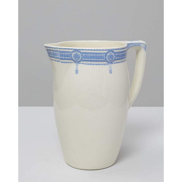 This 20th Century Belgian blue Chinoiserie ceramic pitcher features a refined, minimalist silhouette enhanced by a...