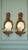A charming pair of vintage Italian Florentine-style gilt wall shelves with integrated oval mirrors and elaborate ribbon-...