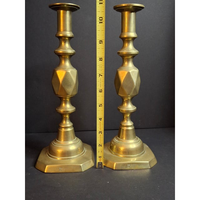 This is an authentic, original matching pair of late Victorian heavy cast brass candlesticks in the famous "The Queen of...