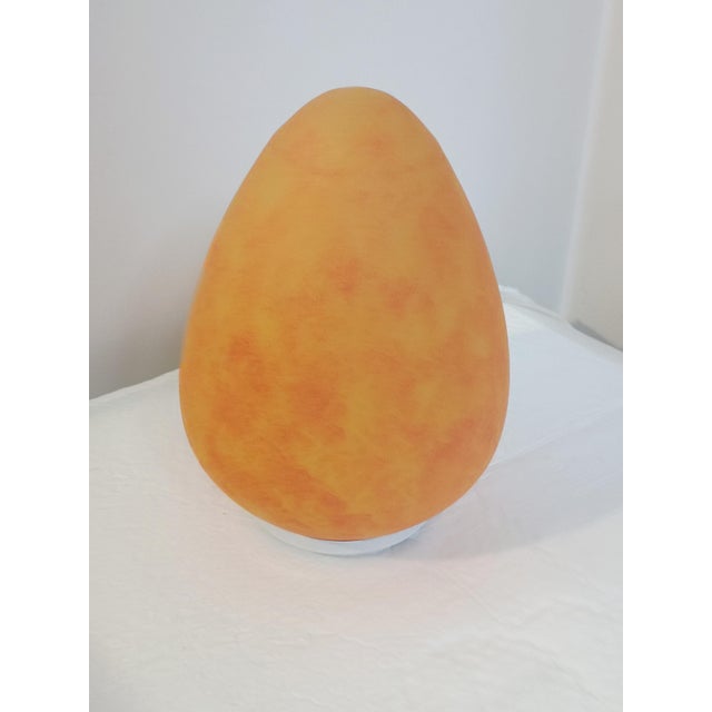 Beautiful egg-shaped table lamp. Italy, 1970s. White lacquered metal base. It supports a lovely opaline glass diffuser....