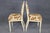 An elegant and beautifully coordinated pair of Louis XVI-style side chairs, distinguished by their finely carved painted...