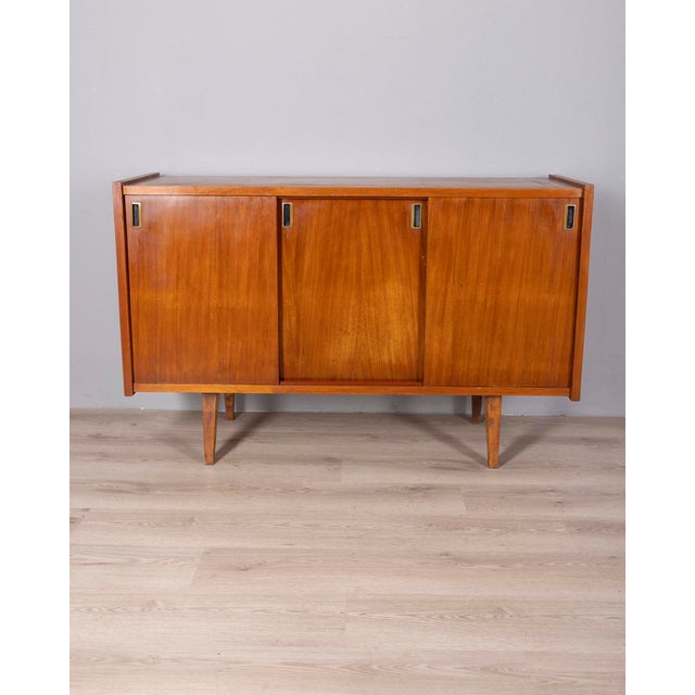 Teak veneered wood sideboard with three sliding doors and black metal handles with gold-plated brass details, Italian...