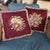 A richly colored pair of vintage floral needlepoint pillows featuring two coordinating bouquet designs against deep...